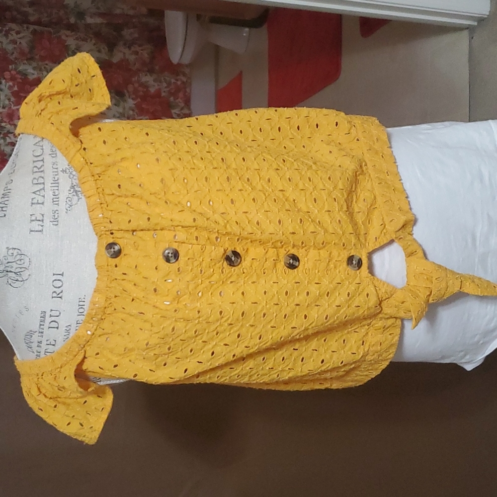 A crop shirt with brown buttons in front size XL.